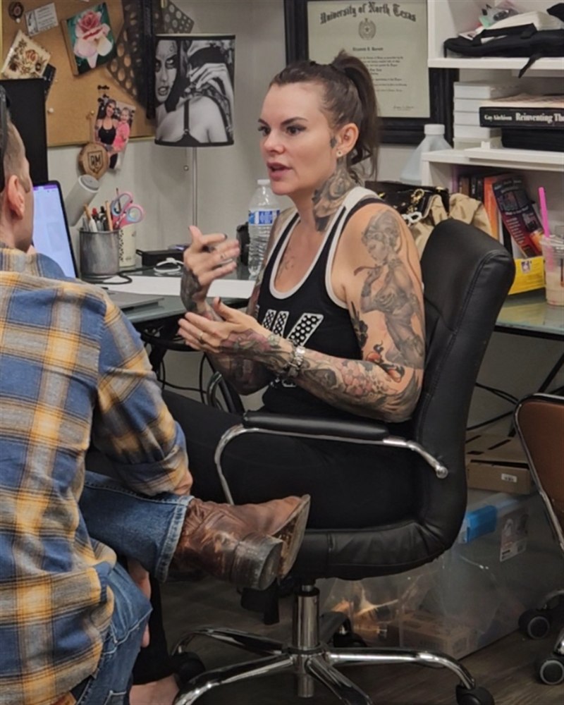 Liz Cook talking with an artist in her studio