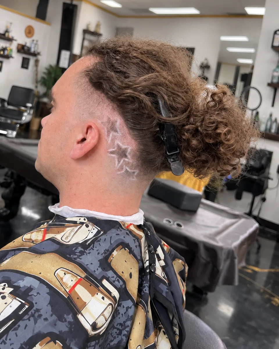 Back view of a neat nape taper with styled waves on the crown