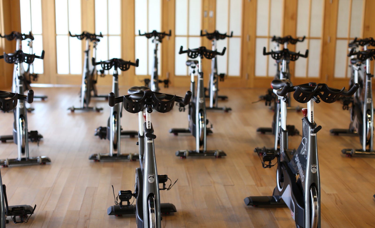 A studio floor with a full row of indoor cycling bikes