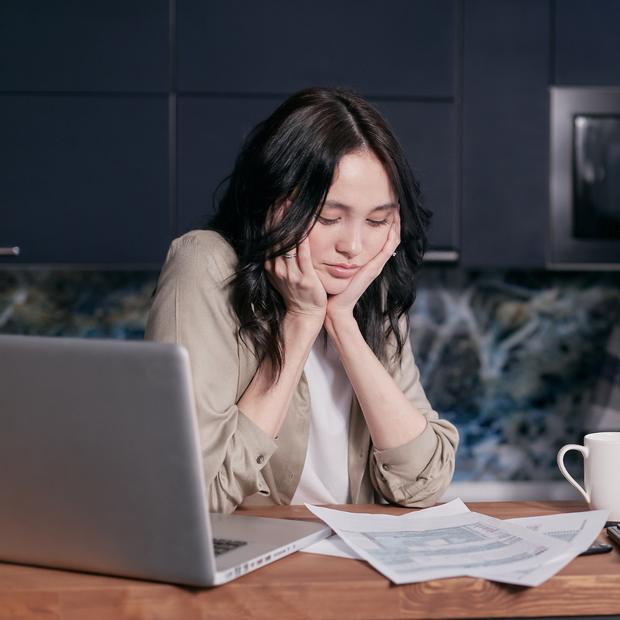 Donna sfinita davanti a preventivi per infissi tutti diversi