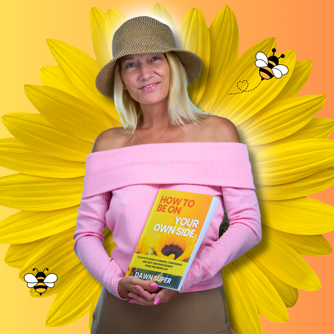 Dawn Super smiling in a pink top and hat while holding her book, How to Be on Your Own Side.