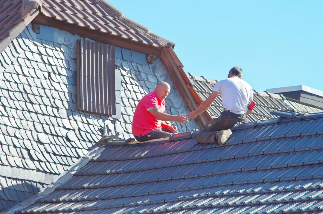 Roofers working on a slate roof
