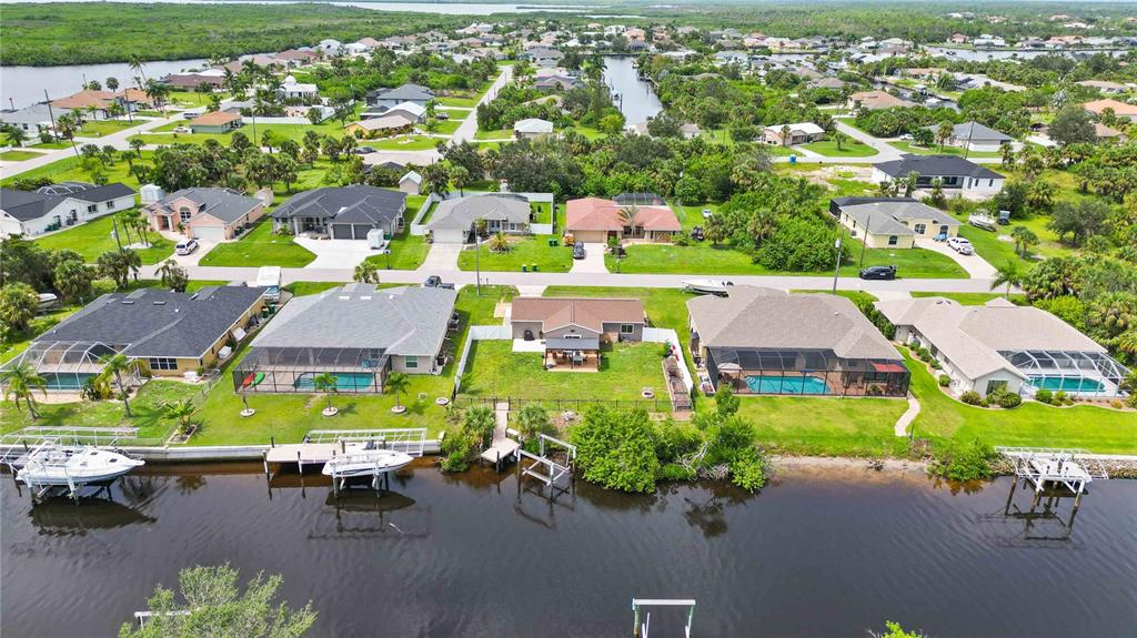 Aerial view of canal-front homes with boat docks in Port Charlotte, Florida