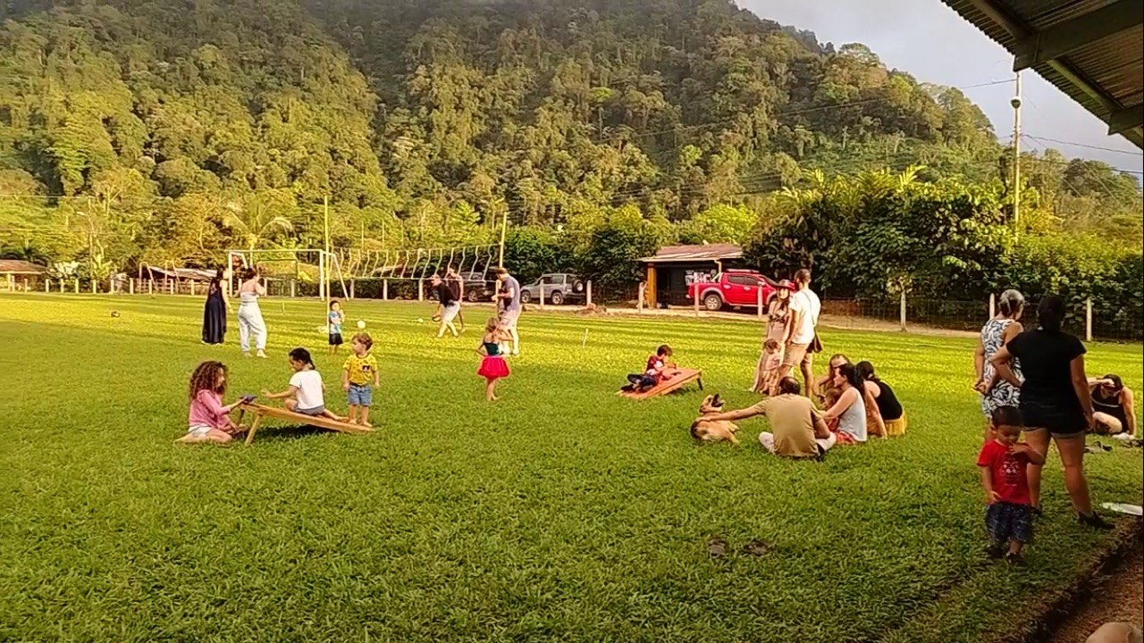 Families gathered on the field beside the center at Las Tumbas