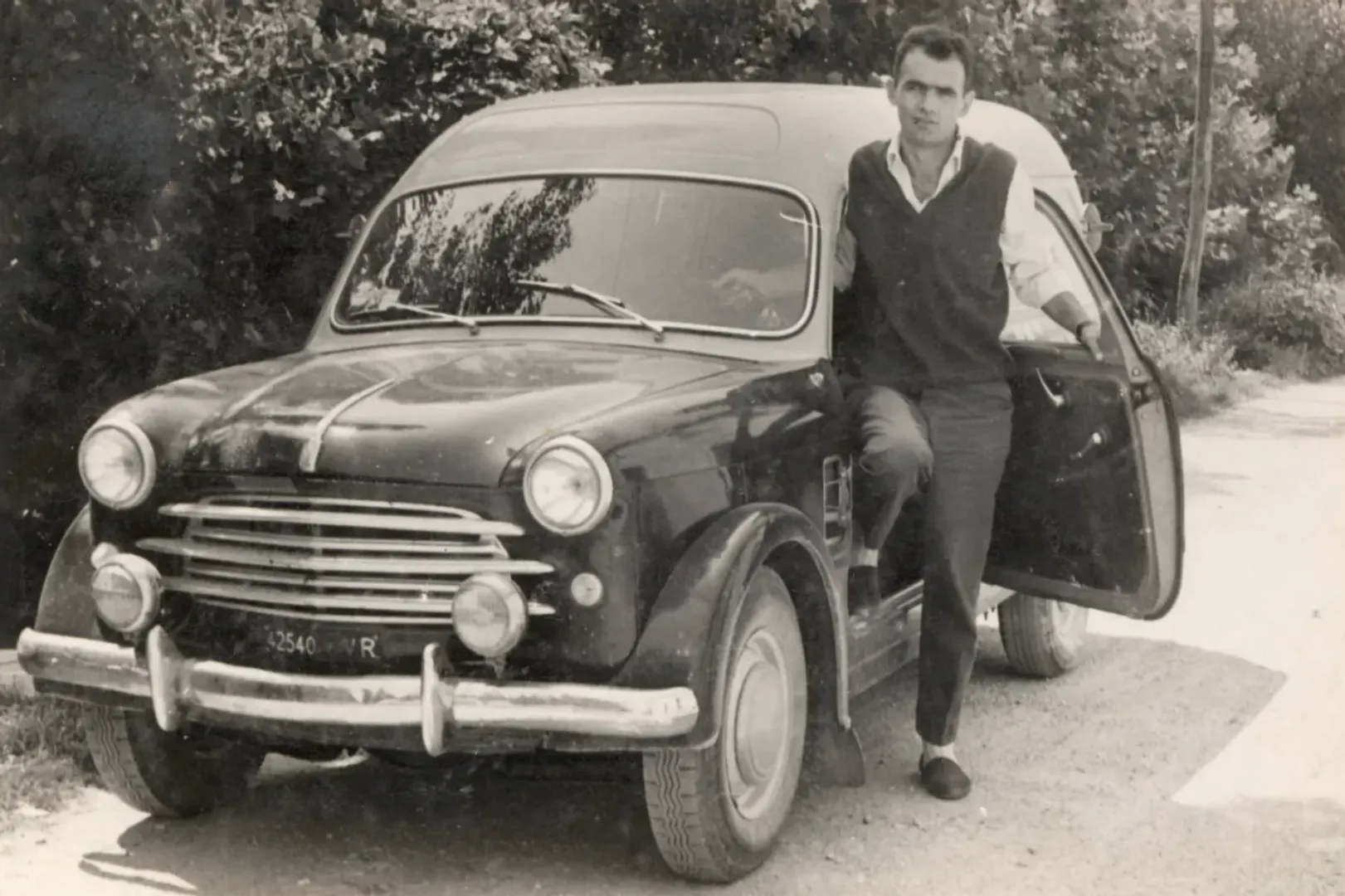 Archival photograph of the Merlin family with a vintage van