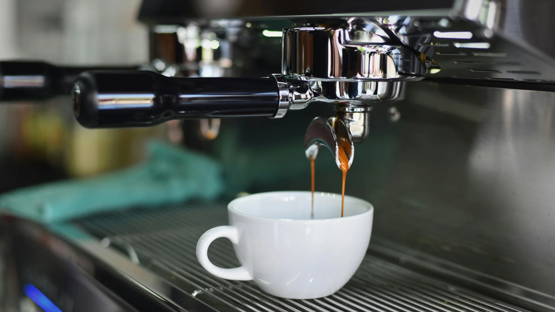 Espresso pouring from a portafilter into a cup