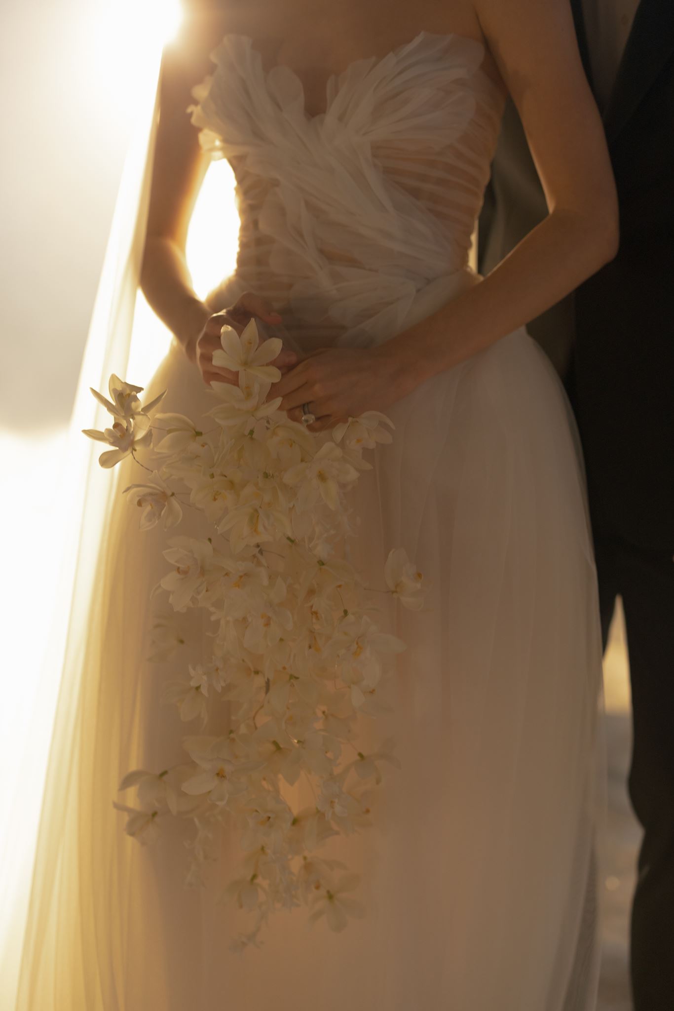 Bride holding white orchid bouquet