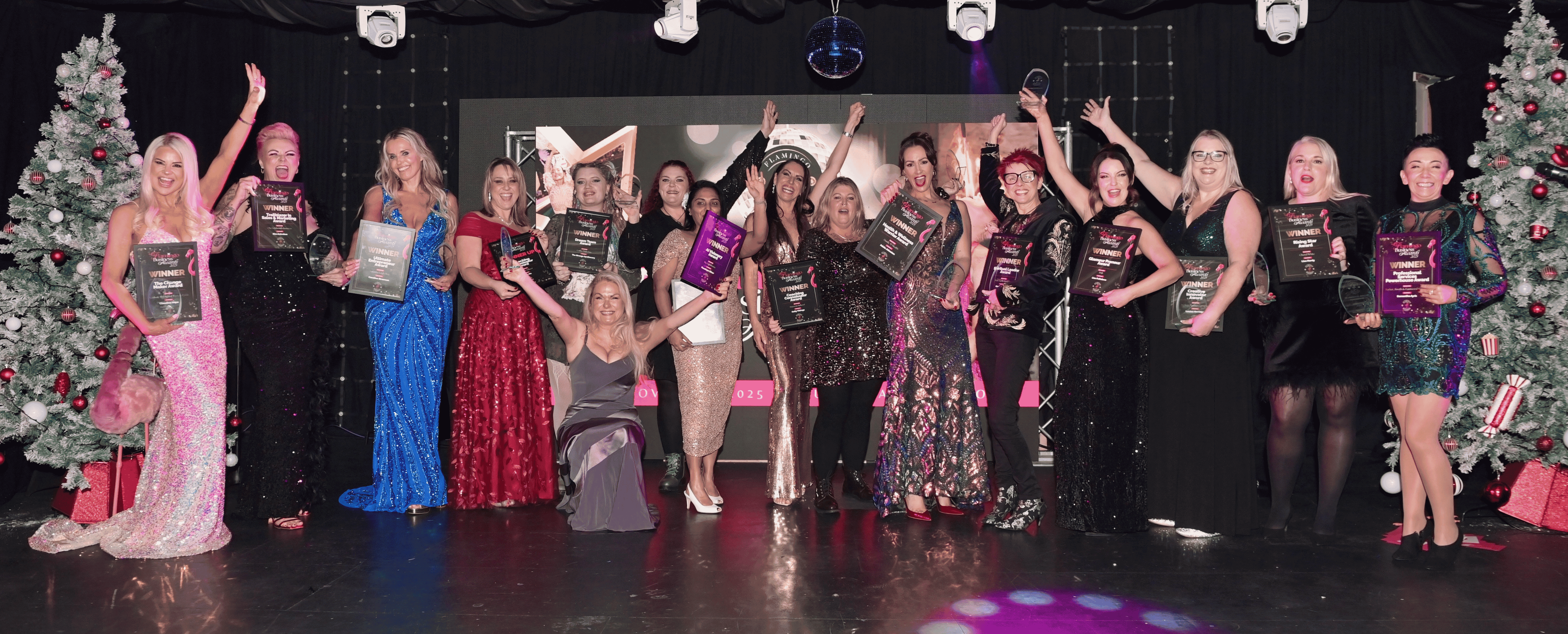 Last year's Flamingo Business Awards winners celebrating together on stage, holding their winner certificates.