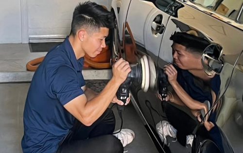 zaro detailing technician polishing a cars paint in a garage 