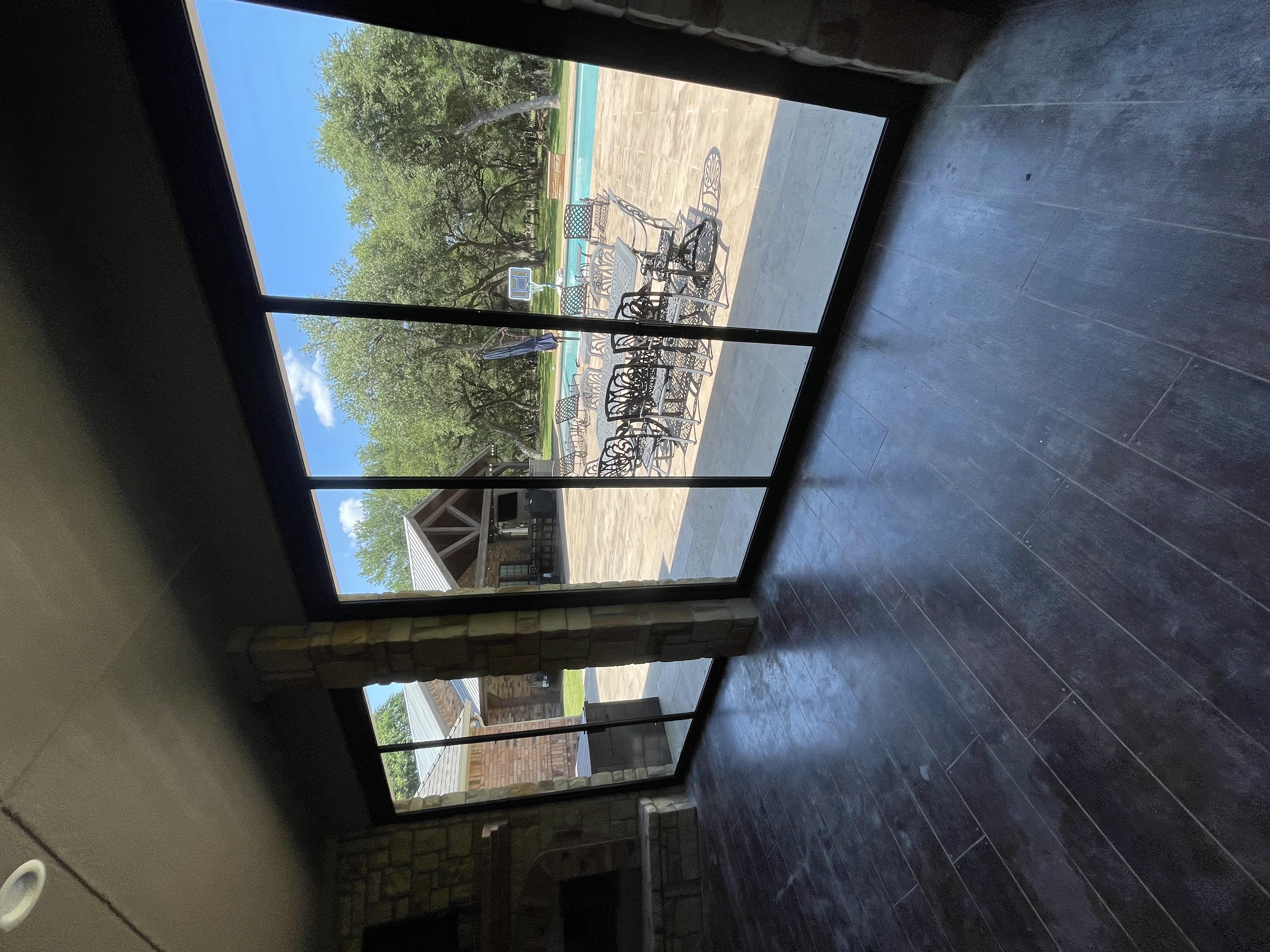 Interior view through large sliding glass doors to a pool