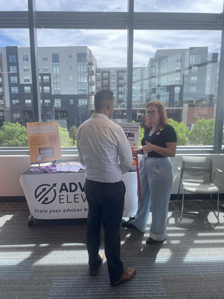Advisor Elevated team member talking with an advisor at an event booth