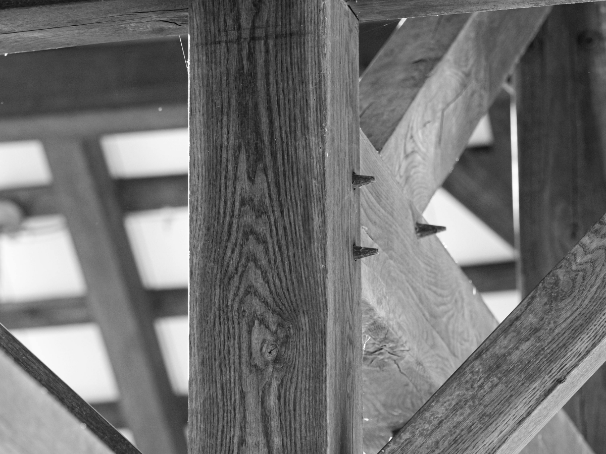 A shot of a massive wood beam being set or a close-up of a complex structural joint. Something that looks "Indestructible."