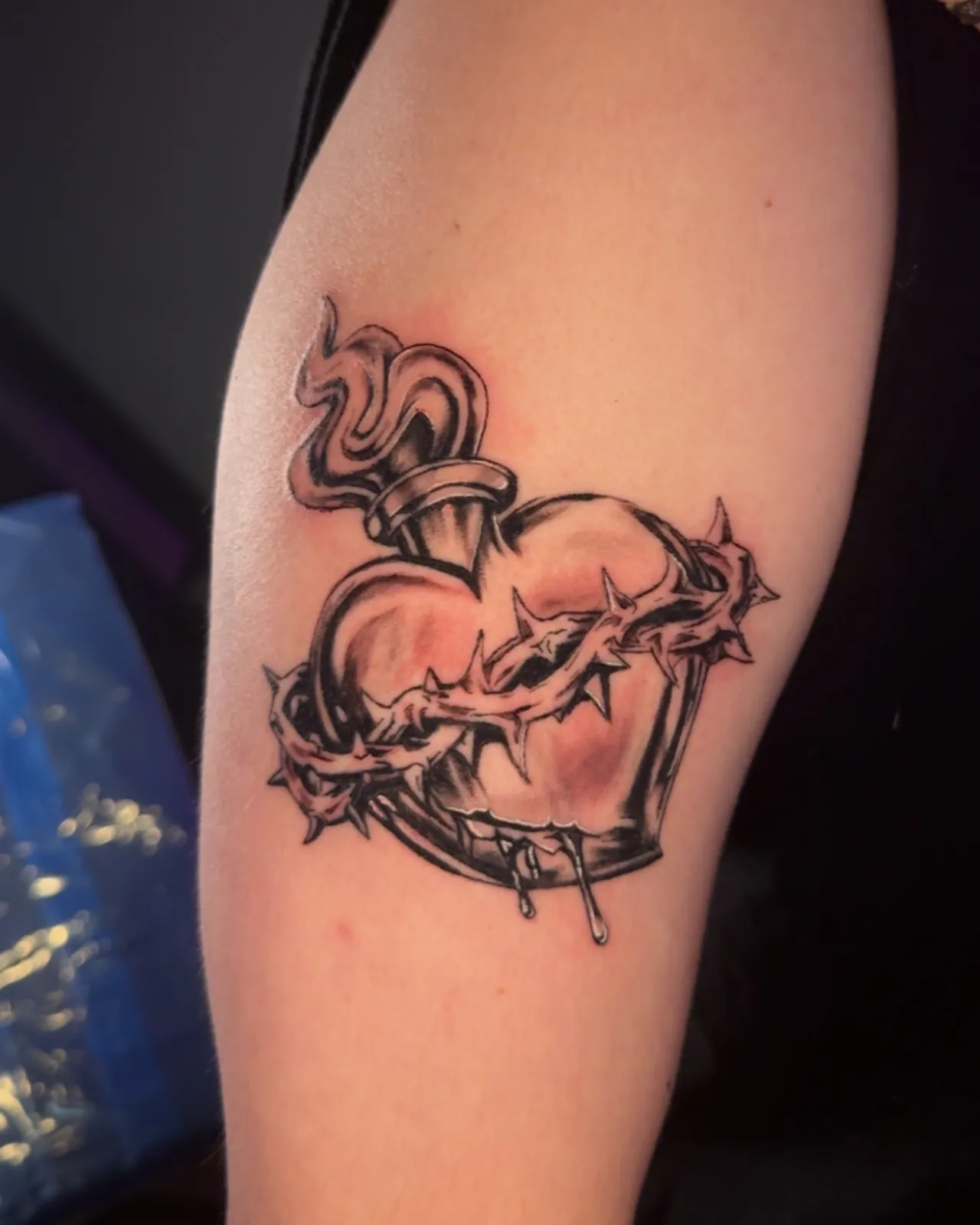 Black and grey sacred heart with crown of thorns upper arm tattoo by Slick at Studio AZ Tattoo Minneapolis
