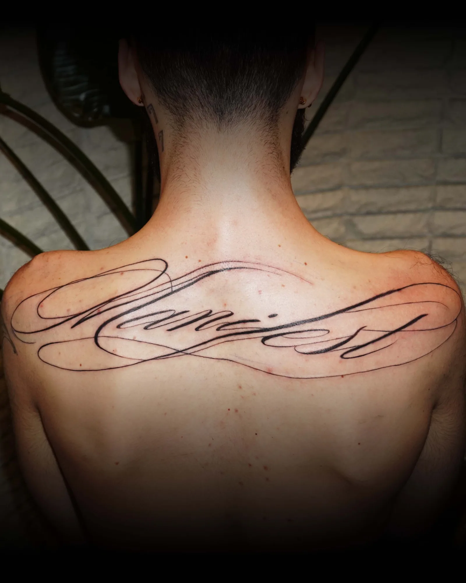 Fine line calligraphy script lettering upper back tattoo by Kaelani Azadi at Studio AZ Tattoo Minneapolis