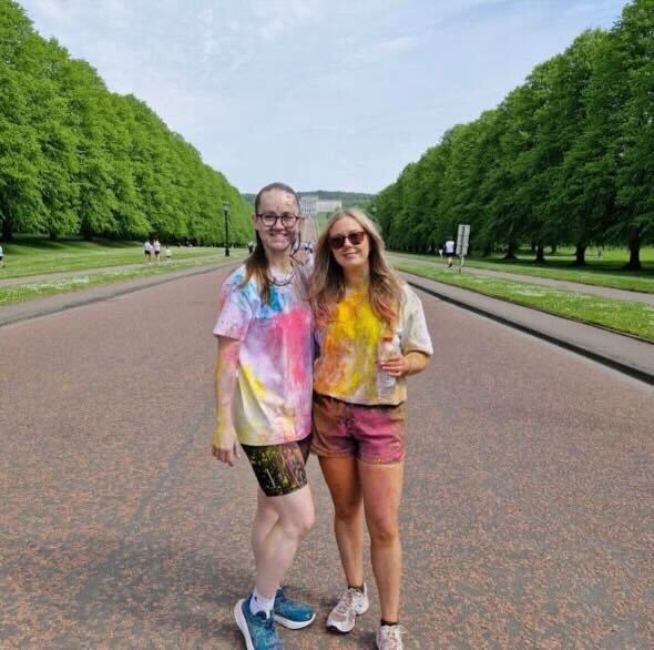 Two coaches covered in colourful powder paint after the SFA colour run at Stormont