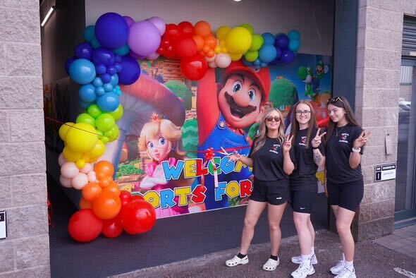 Three Sports 4 Autism coaches posing with peace signs at the venue welcome event