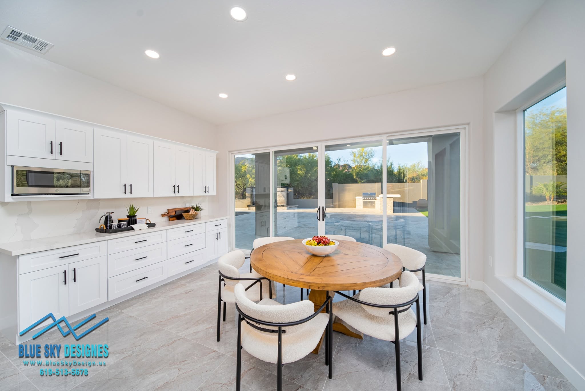Remodeled interior of a Cave Creek, AZ home featuring an open-concept living and kitchen area with earth-toned finishes and desert-modern details. The updated space shows new flooring, refreshed cabinetry, and natural light from large windows framing the Sonoran Desert landscape.