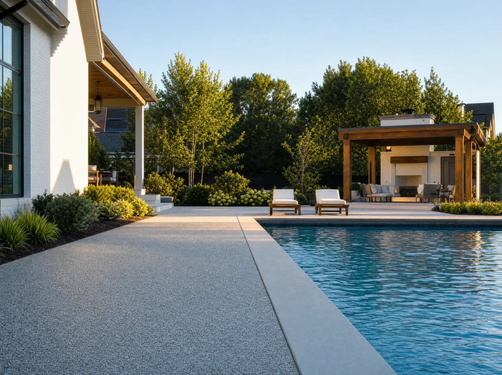 Design concept: Exposed-aggregate pool deck, pitched away from the pool, coping visible.