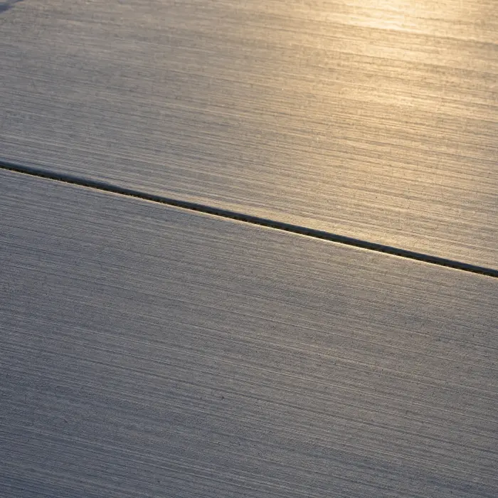 Design concept: broom-finished concrete with fine parallel brush texture and a tooled control joint.