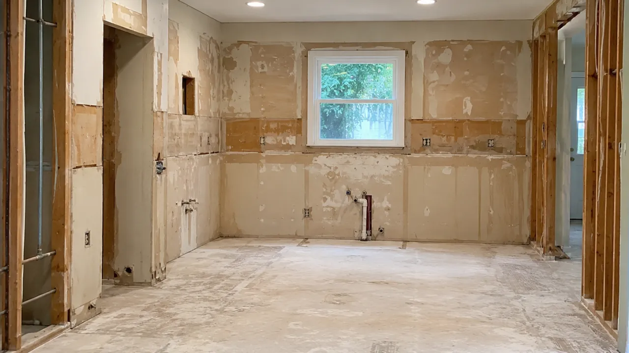 Kitchen stripped to exposed walls and subfloor after a full demolition in Toronto