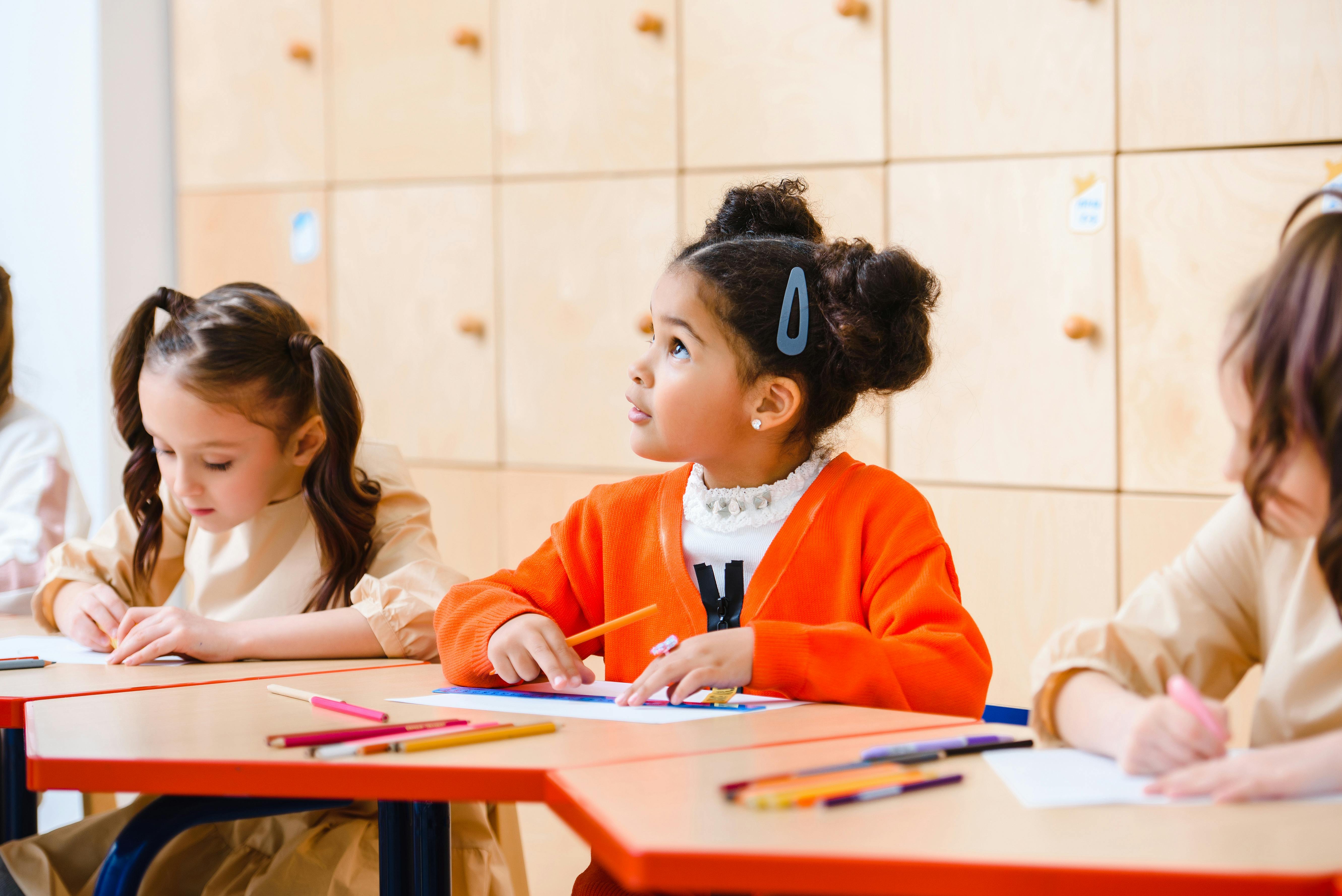An image of a girl looking up curiously at her teacher An image of a girl looking up curiously at her teacher