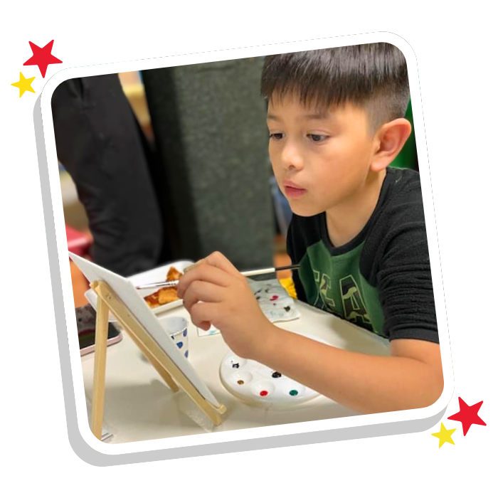 Child focused on creative painting activity at Magic Kingdom Learning Center childcare and preschool in Harlingen TX