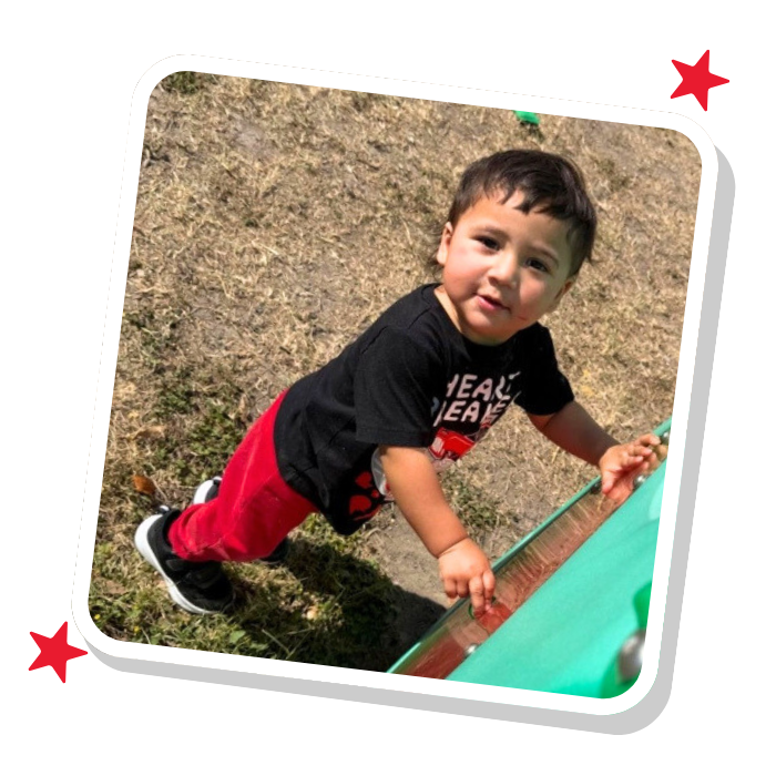 Toddler exploring play in outdoor area at Magic Kingdom Learning Center, developing motor skills and learning through play