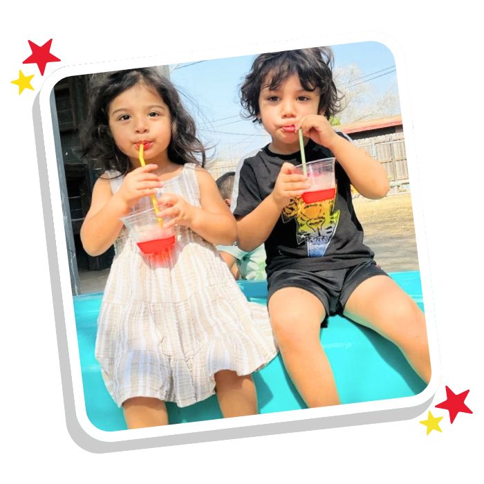 Two young children enjoying drinks outside at Magic Kingdom Learning Center, preparing for kindergarten in Harlingen TX
