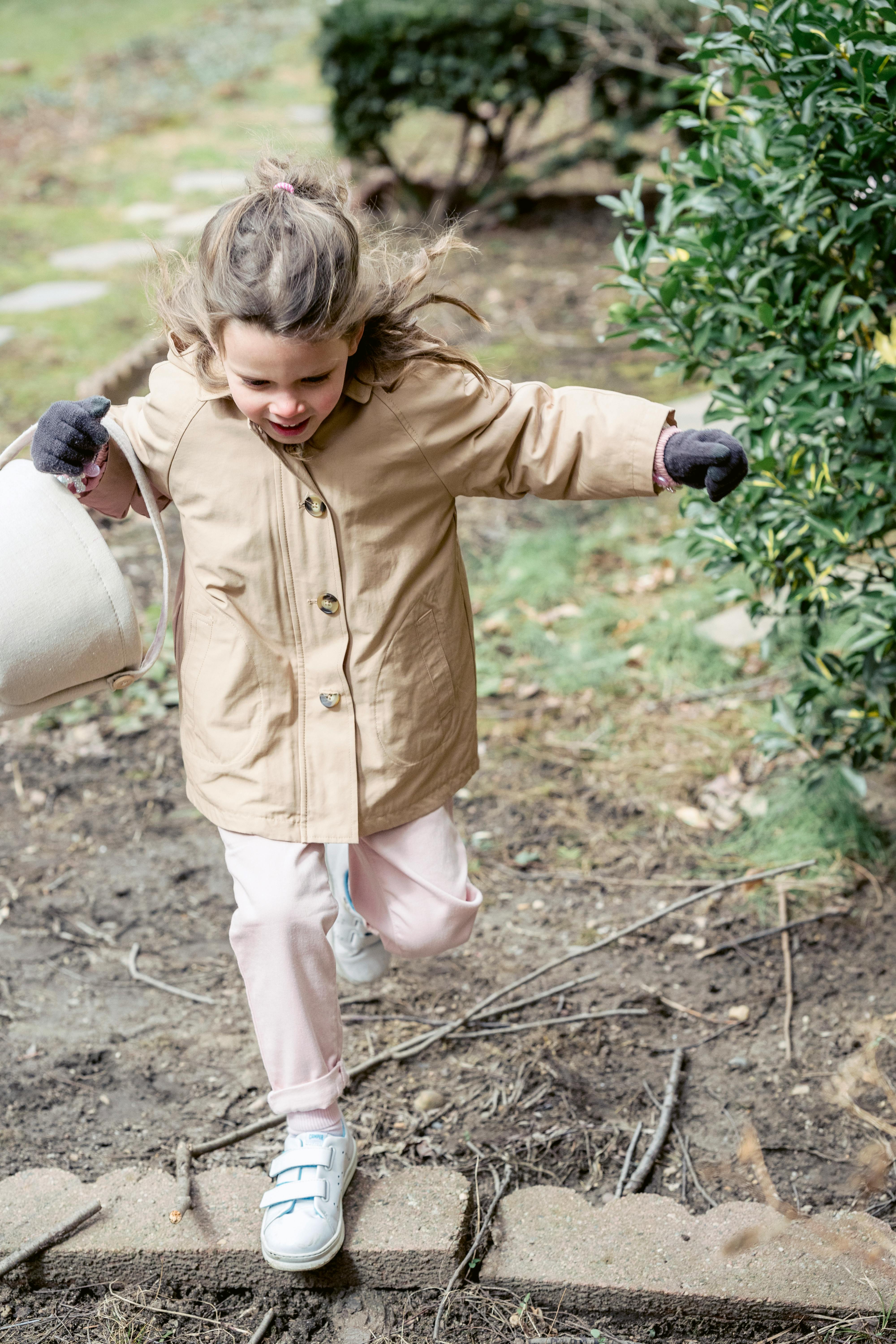An image of a girl running in a garden An image of a girl running in a garden