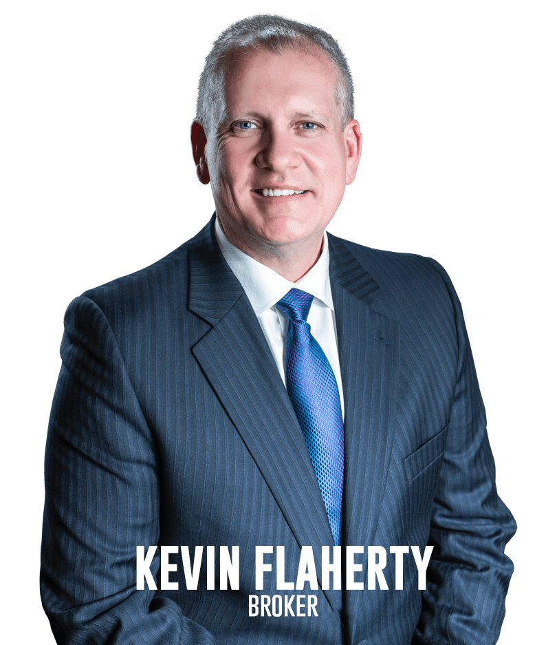 Kevin Flaherty, real estate broker, smiling in a professional suit with a blue tie, representing the Flaherty Team.