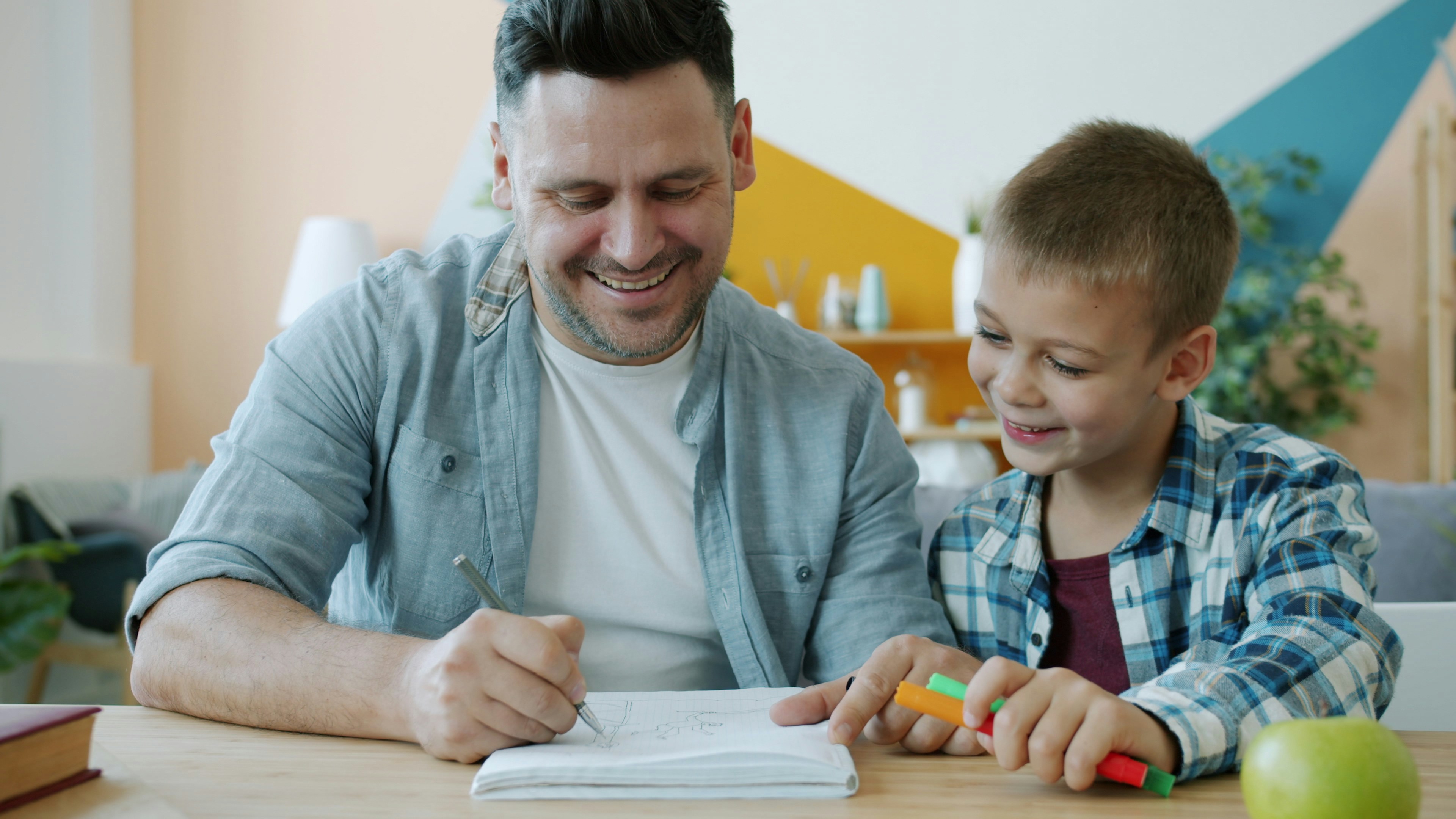 A happy male tutor teaching a young child A happy male tutor teaching a young child