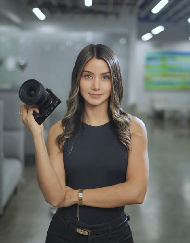 Joselyn, fundadora del estudio, sostiene una cámara y mira con confianza.