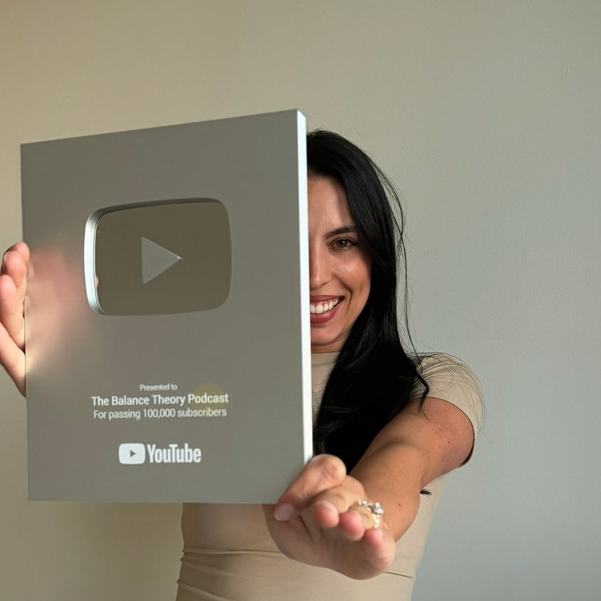 Erika holding The Balance Theory's Silver YouTube plaque