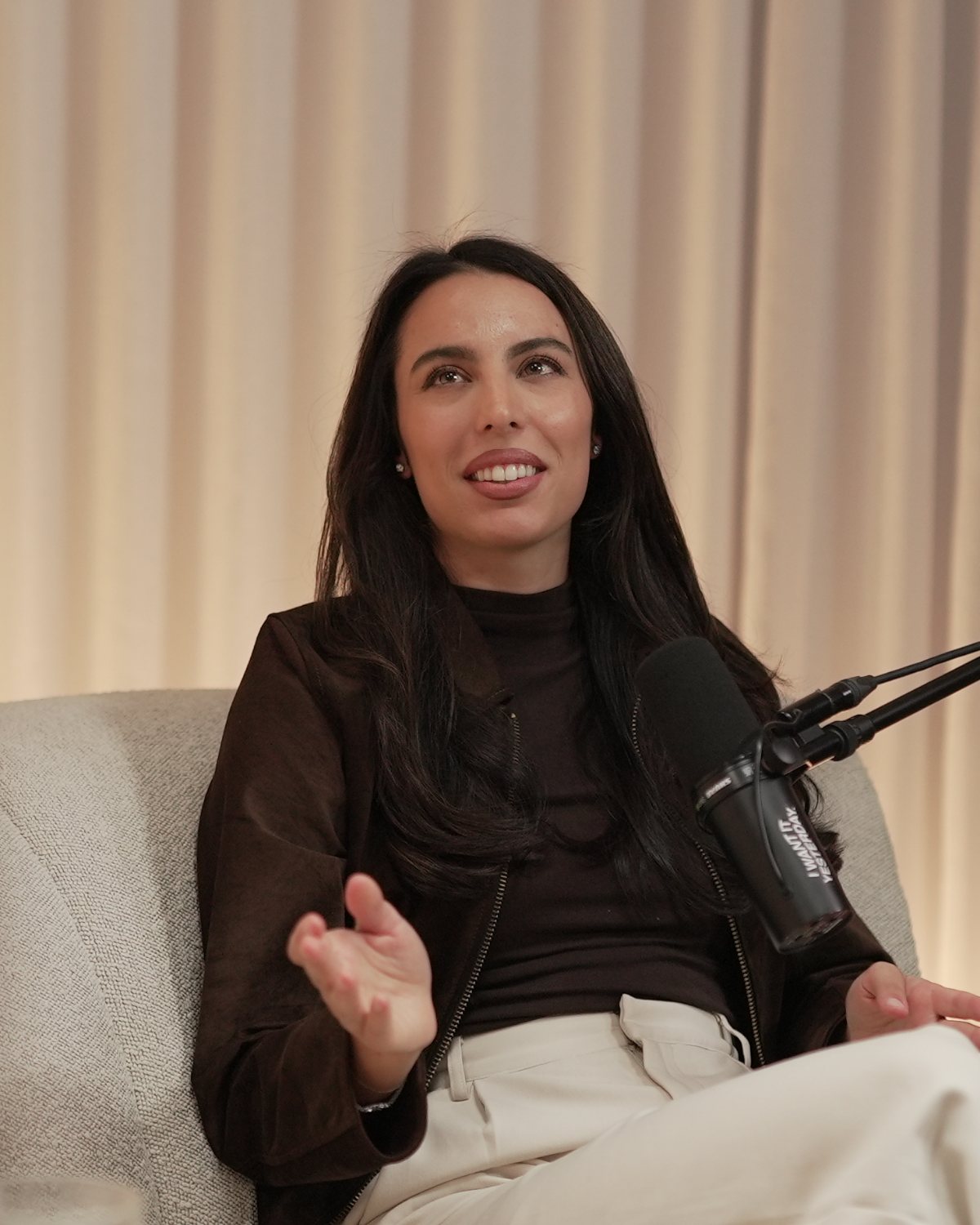 Erika De Pellegrin mid-conversation at the microphone in The Balance Theory studio
