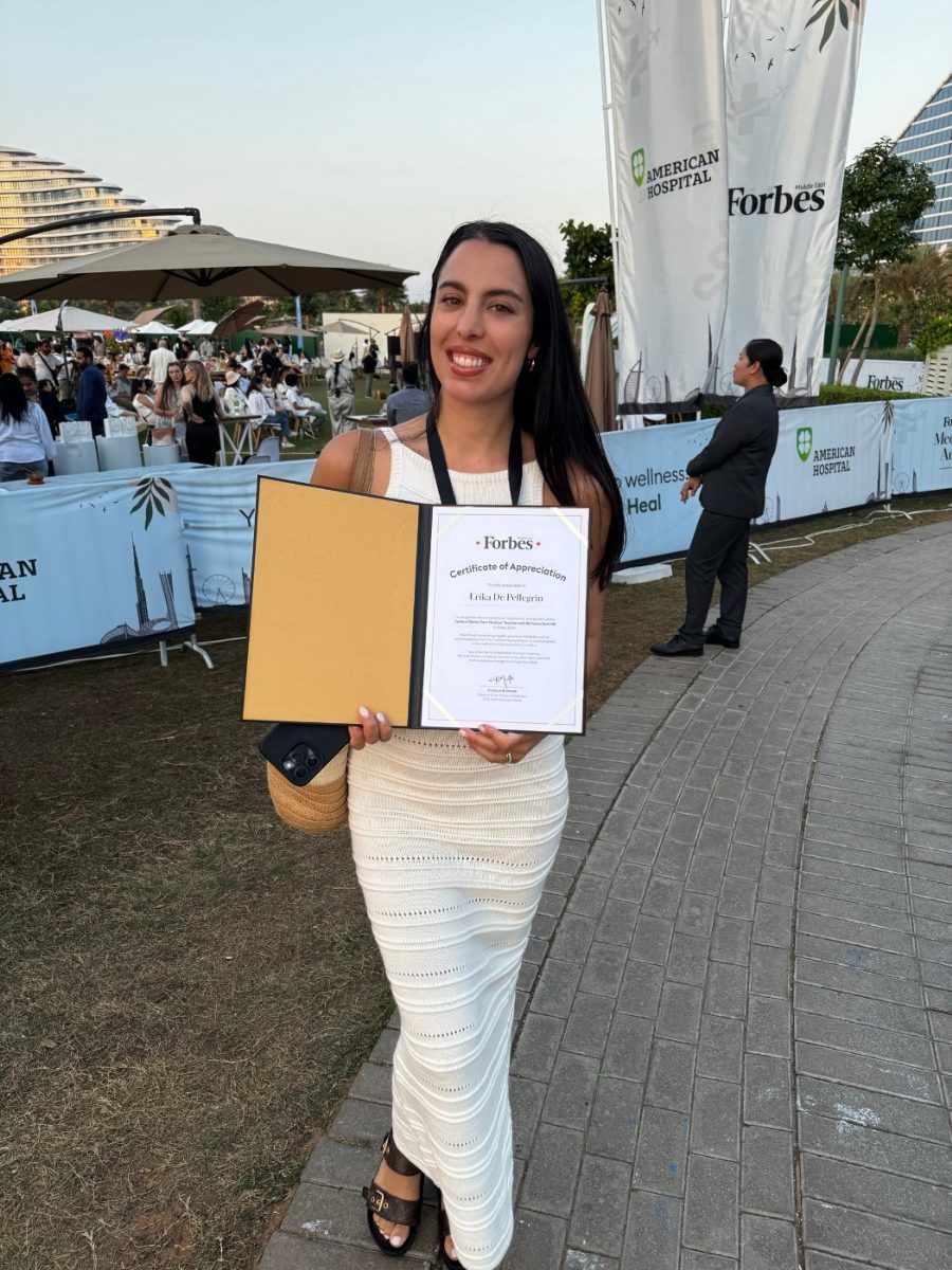 Erika holding a certificate at a Forbes Middle East event