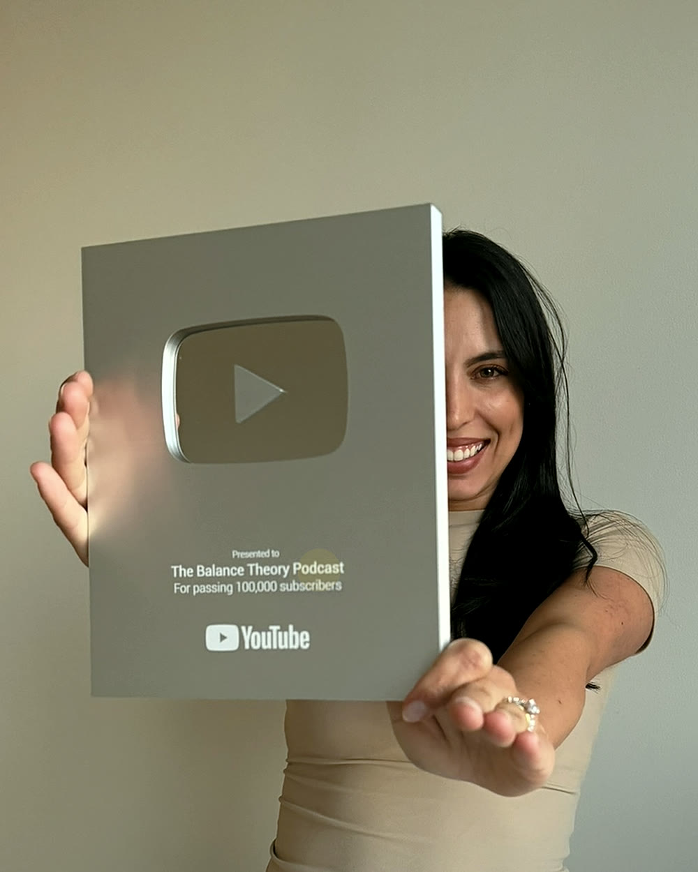 Erika De Pellegrin holding the Silver YouTube plaque presented to The Balance Theory Podcast