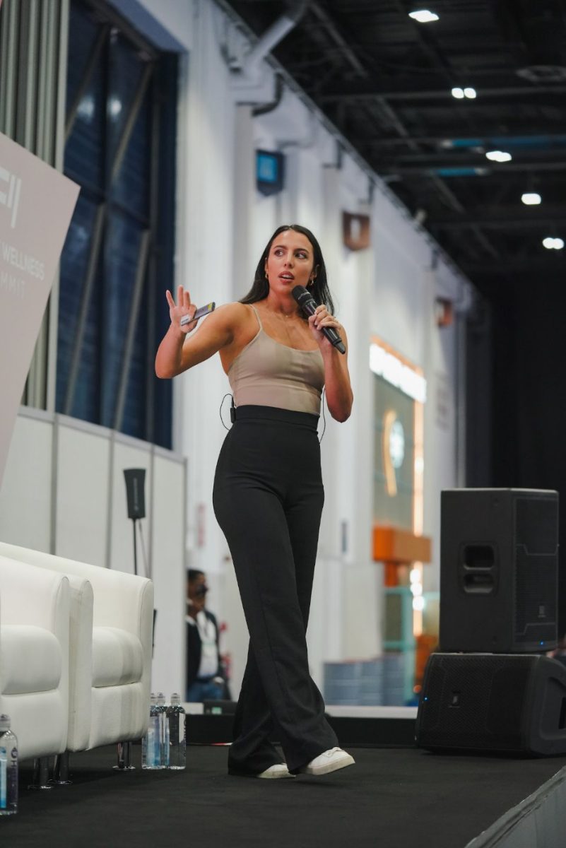 Erika speaking on stage in an exhibition hall