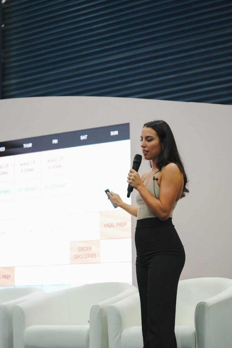 Erika presenting with a slide on screen behind her