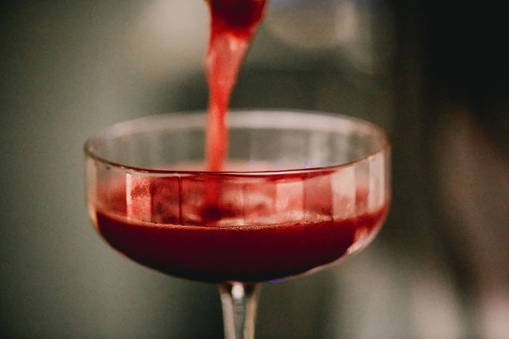 A deep red pour into a coupe