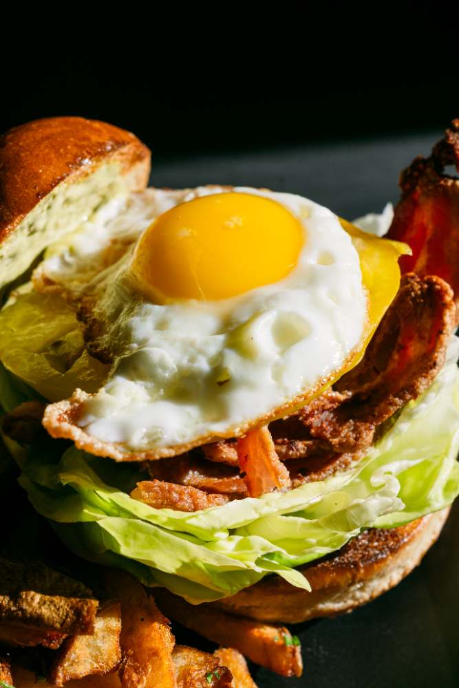 Kaya's fried egg sandwich with bacon, lettuce, and fries