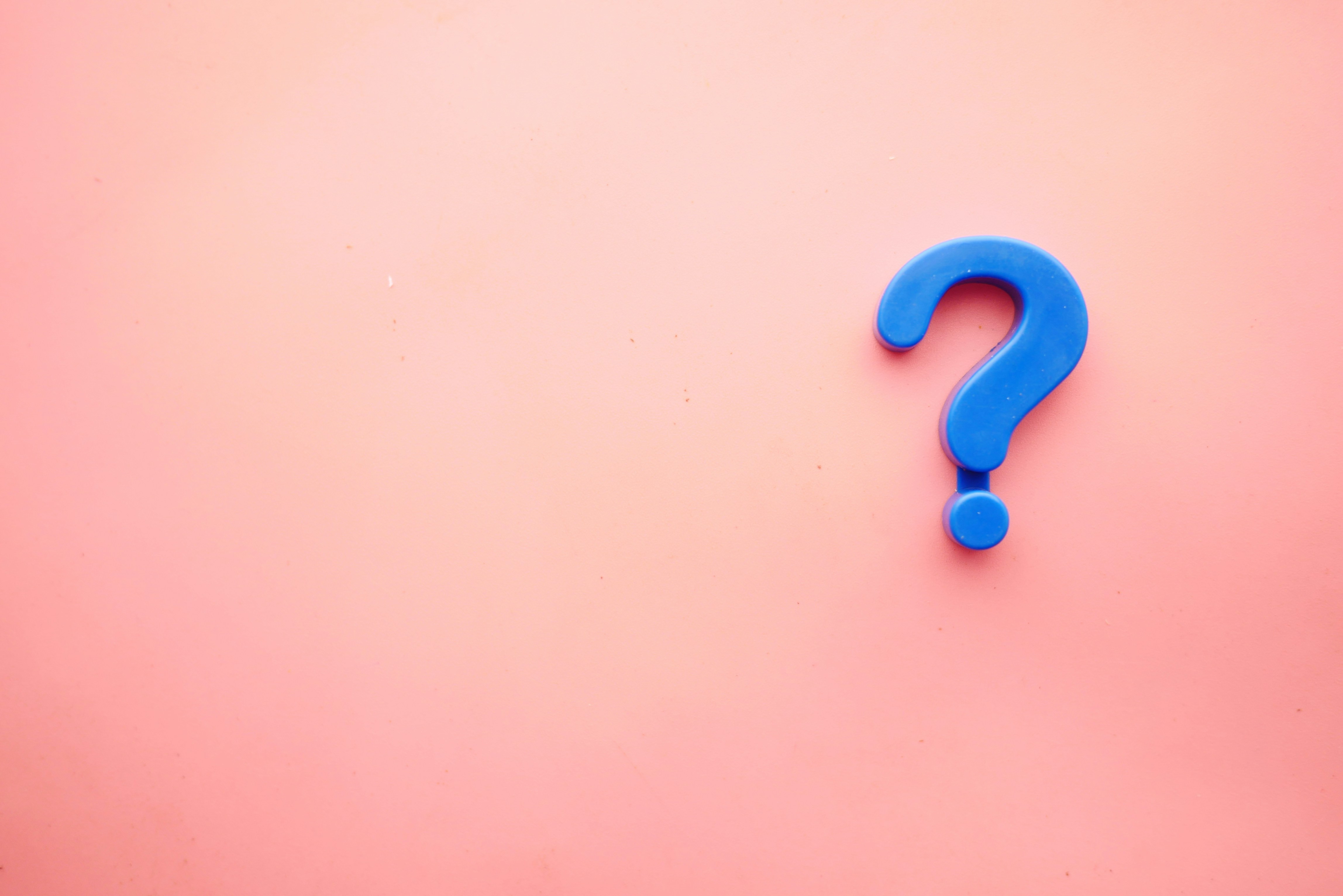 Blue question mark on a pink background representing questions about neurodiversity, disability and reasonable adjustments in the workplace.