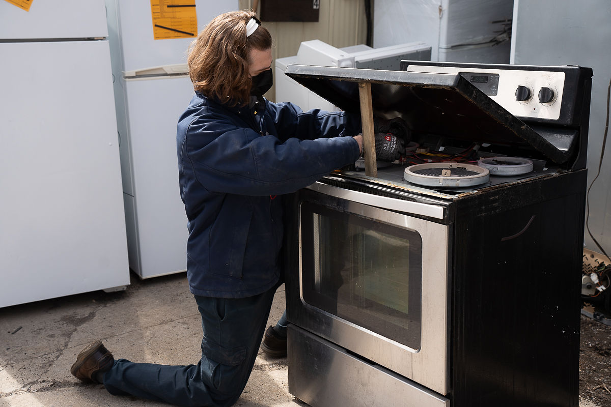 Al's Appliance technician repairing an oven that is not heating