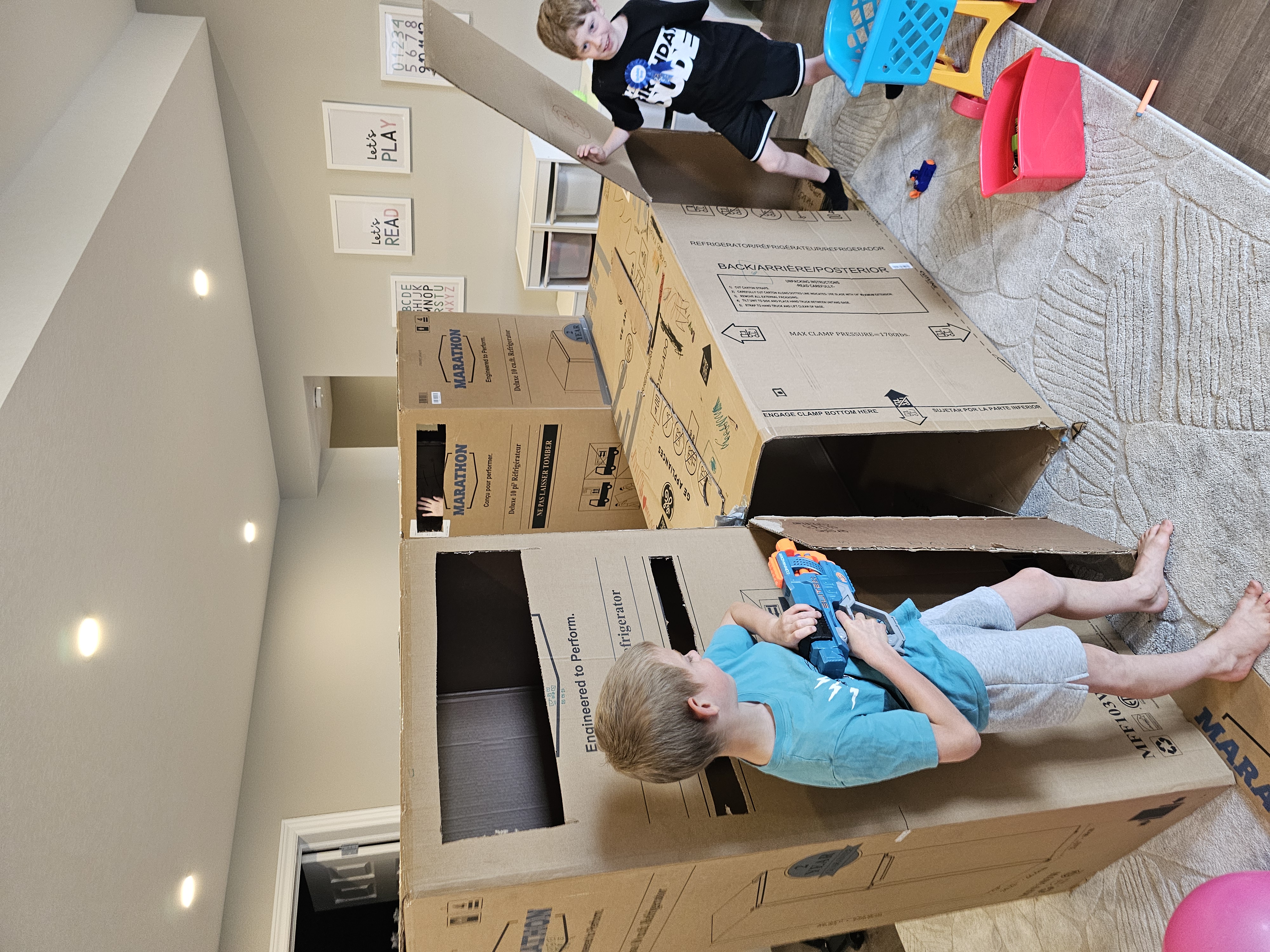 Kids playing in appliance boxes on moving day
