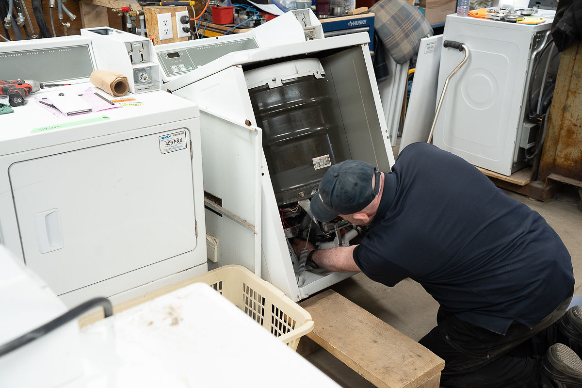 Al's Appliance technician repairing a dryer that is not heating