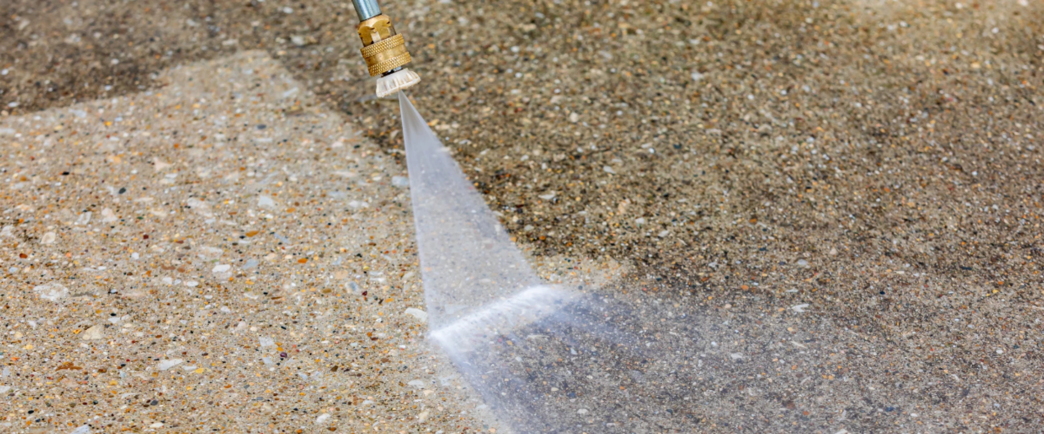 Pressure washing concrete surface to remove dirt and stains using a high pressure water nozzle.