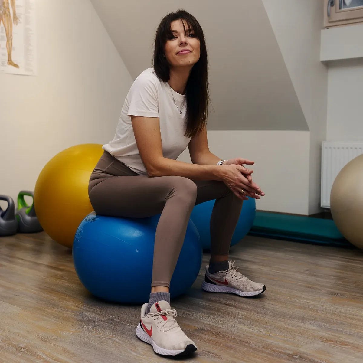 Ieva sėdi ant gimnastikos kamuolio ir šypsosi