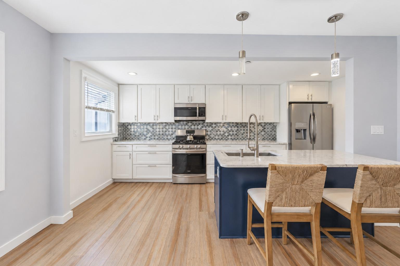 Renovated eat-in kitchen with a navy island and a stainless steel appliance package