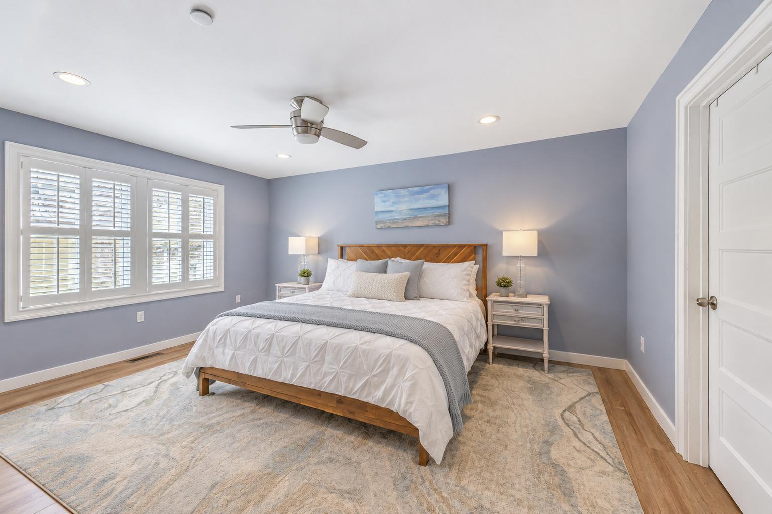 Spacious primary bedroom with blue walls and abundant windows