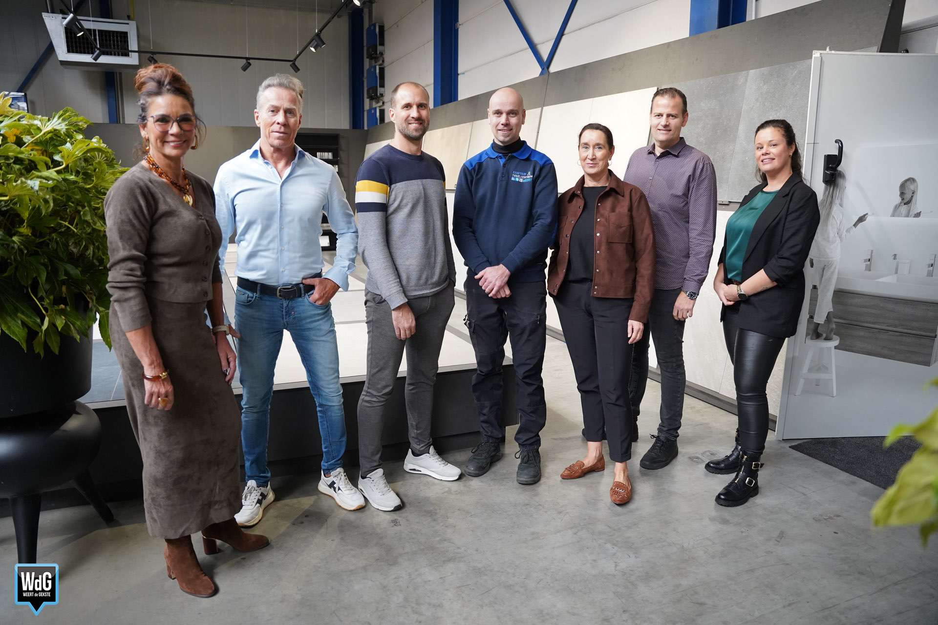 Medewerker adviseert een klant bij de tegelwand