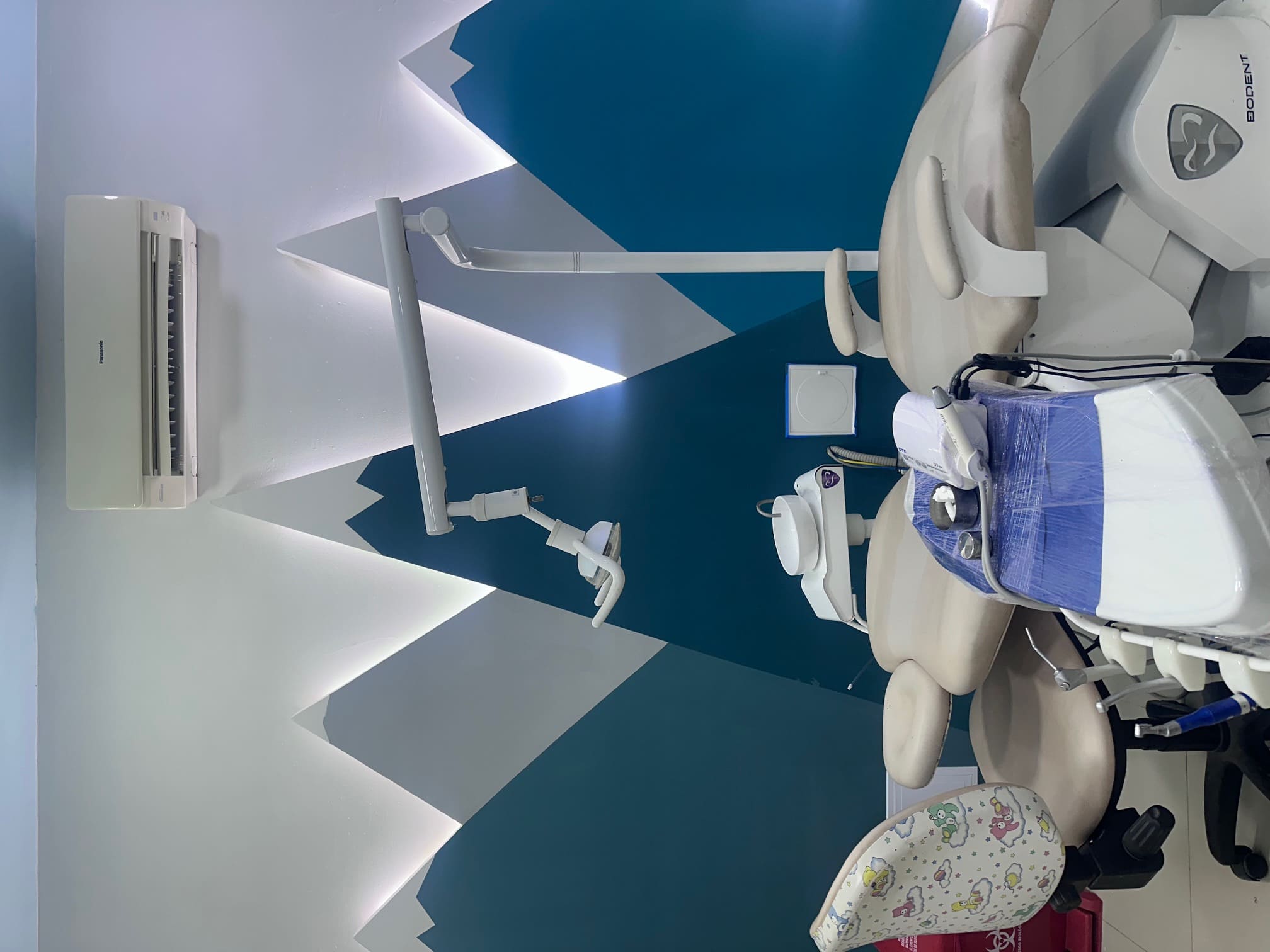Rincón de juegos con estantes hexagonales de juguetes en el consultorio de odontopediatría en Santa Marta